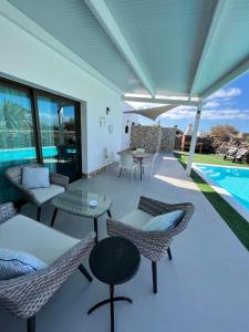 a patio with chairs and tables next to a pool at LA ERA 2 in El Cotillo