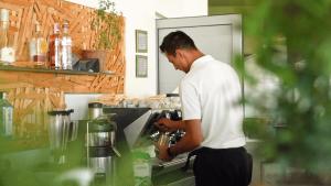 un homme debout dans une cuisine préparant la nourriture dans l'établissement Easyatent Camping Porto Sole, à Vrsar