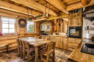 una cucina con tavolo e sedie in una cabina di Chata Góralska Exclusive SPA - Lipowa Beskidy a Lipowa