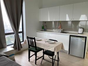 a kitchen with a table and chairs and a kitchen with white cabinets at The Grand#11, Free Parking,2pax in Petaling Jaya