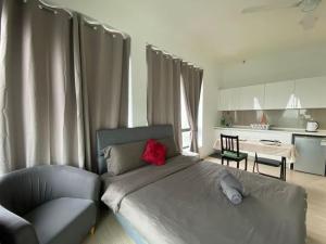 a bedroom with a bed and a chair and a kitchen at The Grand#11, Free Parking,2pax in Petaling Jaya