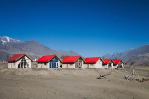 a row of houses with red roofs in the desert at Oasis Resort in Skardu