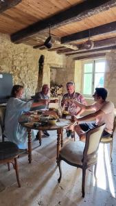 a group of people sitting around a table in a room at Airbnb: Vieilles Pierres et Rivière en Périgord in Couze-et-Saint-Front +19 photos