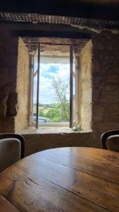 a wooden table in a room with a window at Airbnb: Vieilles Pierres et Rivière en Périgord in Couze-et-Saint-Front