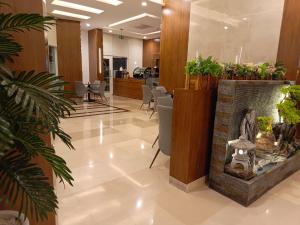 een lobby met een open haard en stoelen en planten bij Hill Top Muscat in Muscat