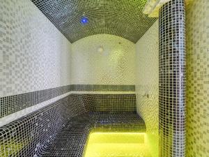 a bathroom with a shower with a yellow bench in it at Hotel Jan in Szczawnica