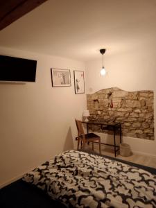 a bedroom with a bed and a desk and a stone wall at Amnis in Aquiléia