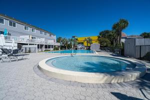 una piscina en un patio junto a un edificio en SOUTH BAY BY THE GULF- Private beach access, Community pool, Foosball, en Destin