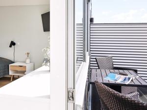 een kamer met een balkon met een tafel en stoelen bij athome apartments in Aarhus