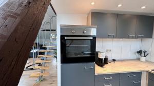 a kitchen with a stove and a spiral staircase at Modernes City-Apartment in Mönchengladbach in Mönchengladbach