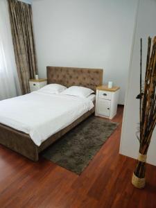 a bedroom with a large bed and two night stands at Iosia Premium Apartment in Oradea