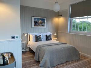 a bedroom with a bed with blue pillows and a window at The Old Bell in Grimston