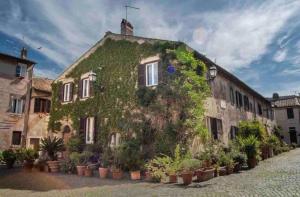 an ivycovered building with plants on the side of it at Felici’s apartment agli scavi di Ostia Antica in Ostia Antica