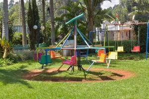 a playground with colorful equipment in the grass at Gatimene Gardens Hotel in Meru
