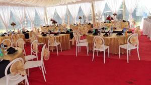 a banquet hall with tables and chairs in a tent at Balmoral Beach Hotel Kisumu in Kisumu