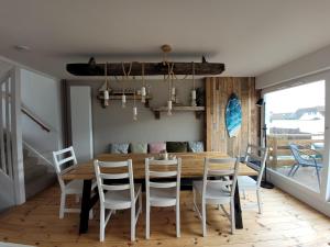 a dining room with a wooden table and chairs at No 28 Contemporary beach side property with sea views in Chichester