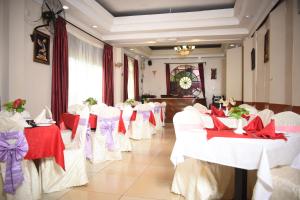a row of tables with red and white chairs in a room at Gatimene Gardens Hotel in Meru