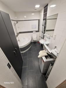 a bathroom with a tub and a toilet and a sink at Apartmány pod Klášterem in Kladruby