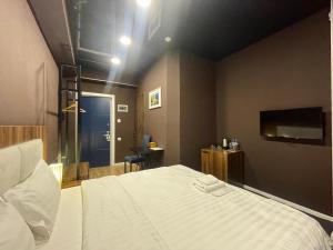 Schlafzimmer mit einem großen weißen Bett und einem Schreibtisch in der Unterkunft Hotel West in Tbilisi City