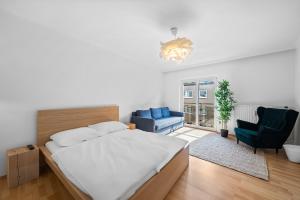 ein Schlafzimmer mit einem großen Bett und zwei Stühlen in der Unterkunft Flora Collection in Wien