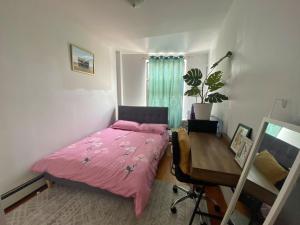um quarto com uma cama rosa e uma secretária em #4 Travelers -Brooklyn - Private Room & Workspace - Shared Bath By Zen Living Short Term Rental em Brooklyn