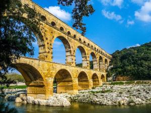 a bridge with arches on the side of a river at Le Vintage, Appart,Hôtel particulier, centre Nîmes MaisonCarréeConciergerie in Nîmes