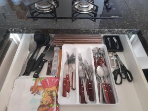 uma gaveta cheia de utensílios em cima de um balcão em Apartamento bem localizado em Bento Gonçalves