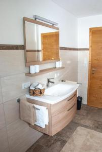 ein Bad mit einem Waschbecken und einem Spiegel in der Unterkunft Ferienwohnung Kant in Fieberbrunn