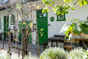 a building with a green door and a picnic table at Czakó Bed&Breakfast in Budapest