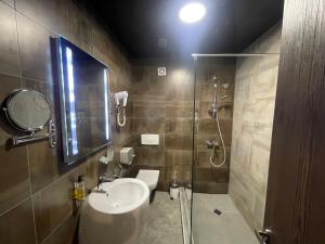 uma casa de banho com um lavatório e um chuveiro em Hotel West em Tbilisi