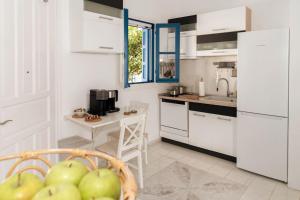 a kitchen with white cabinets and a basket of apples at Green Apple in Pollonia