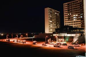 un parking avec des voitures garées devant un bâtiment dans l'établissement Studio 308 no Parque Una com garagem, à Pelotas