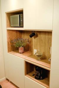 a kitchen with a cupboard with a microwave at Studio 308 no Parque Una com garagem in Pelotas