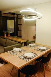 a dining room table with plates and wine glasses on it at Studio 308 no Parque Una com garagem in Pelotas