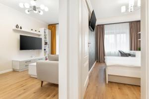 ein Schlafzimmer und ein Wohnzimmer mit einem Bett und einem TV in der Unterkunft Mixit Flat in Oradea