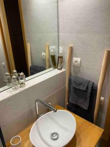 La salle de bains est pourvue d'un lavabo blanc et d'un miroir. dans l'établissement Bel appartement au centre gueliz, à Marrakech