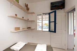 Zimmer mit weißen Wänden, einer Tür und Regalen in der Unterkunft Green Apple in Pollonia