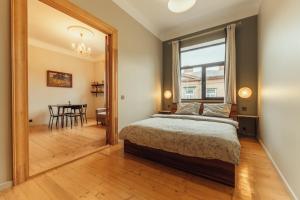 een slaapkamer met een bed en een eetkamer met een tafel bij Barinu apartments in Liepāja