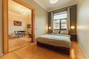 Un dormitorio con una cama y un comedor con una mesa. en Barinu apartments, en Liepāja