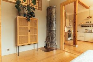 una sala de estar con suelo de madera y una columna en Barinu apartments, en Liepāja