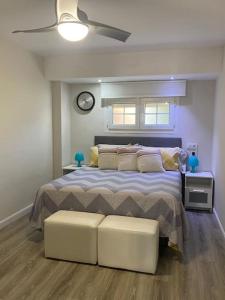 1 dormitorio con 1 cama con 2 reposapiés blancos en Casa Aries - Villa con piscina privada, en Linares