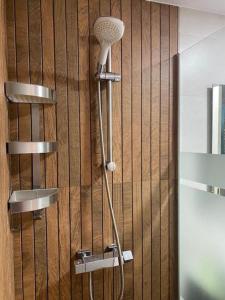 a shower in a bathroom with a wooden wall at Casa Aries - Villa con piscina privada in Linares