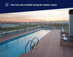 a swimming pool on the roof of a building at DoubleTree by Hilton Girona in Girona