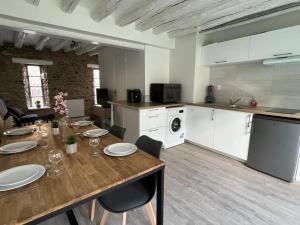 a kitchen with a wooden table and a dining room at Maison à 6min du Parc Disneyland Paris in Magny-le-Hongre