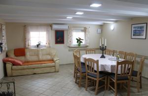 a living room with a table and a couch at Vila Tamaškut in Lendava