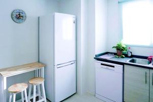 ガンディアにあるEstupendo apartamento en el graoの白い冷蔵庫とシンクのあるキッチン