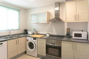 ガンディアにあるEstupendo apartamento en el graoの洗濯機と電子レンジ付きのキッチン