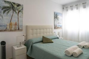 a bedroom with a bed with towels on it at Estupendo apartamento en el grao in Gandía