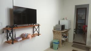 einen Flachbild-TV an der Wand in einem Zimmer in der Unterkunft Suíte privativa 11km vila germânica in Blumenau