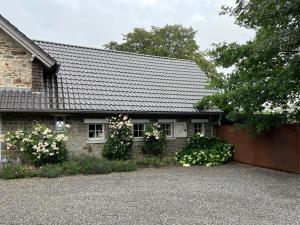 ein Backsteinhaus mit Zaun und Blumen in der Unterkunft Maison Galerie Art n Pepper in Solwaster
